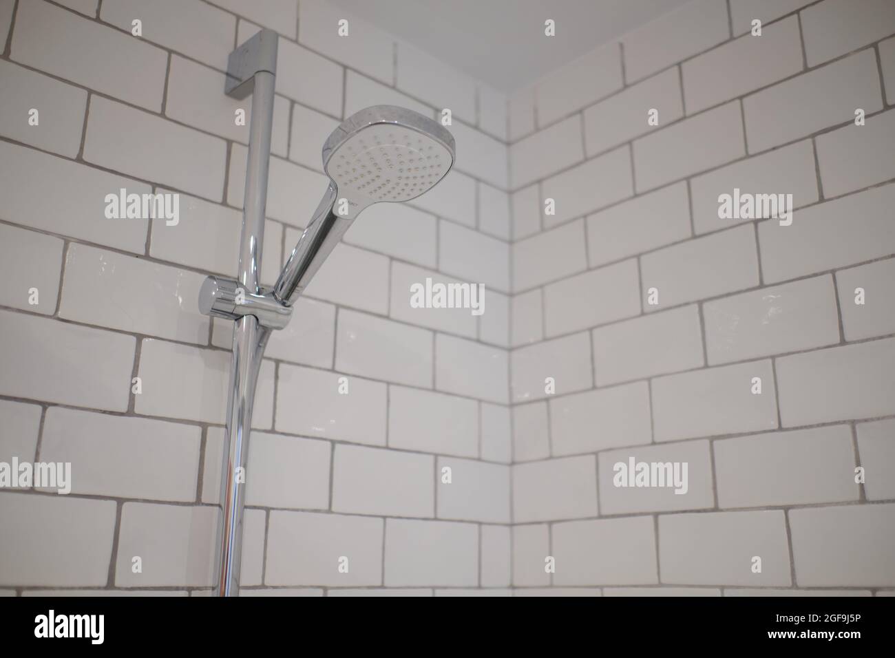 https://c8.alamy.com/comp/2GF9J5P/modern-shower-with-white-tiles-handheld-shower-head-2GF9J5P.jpg