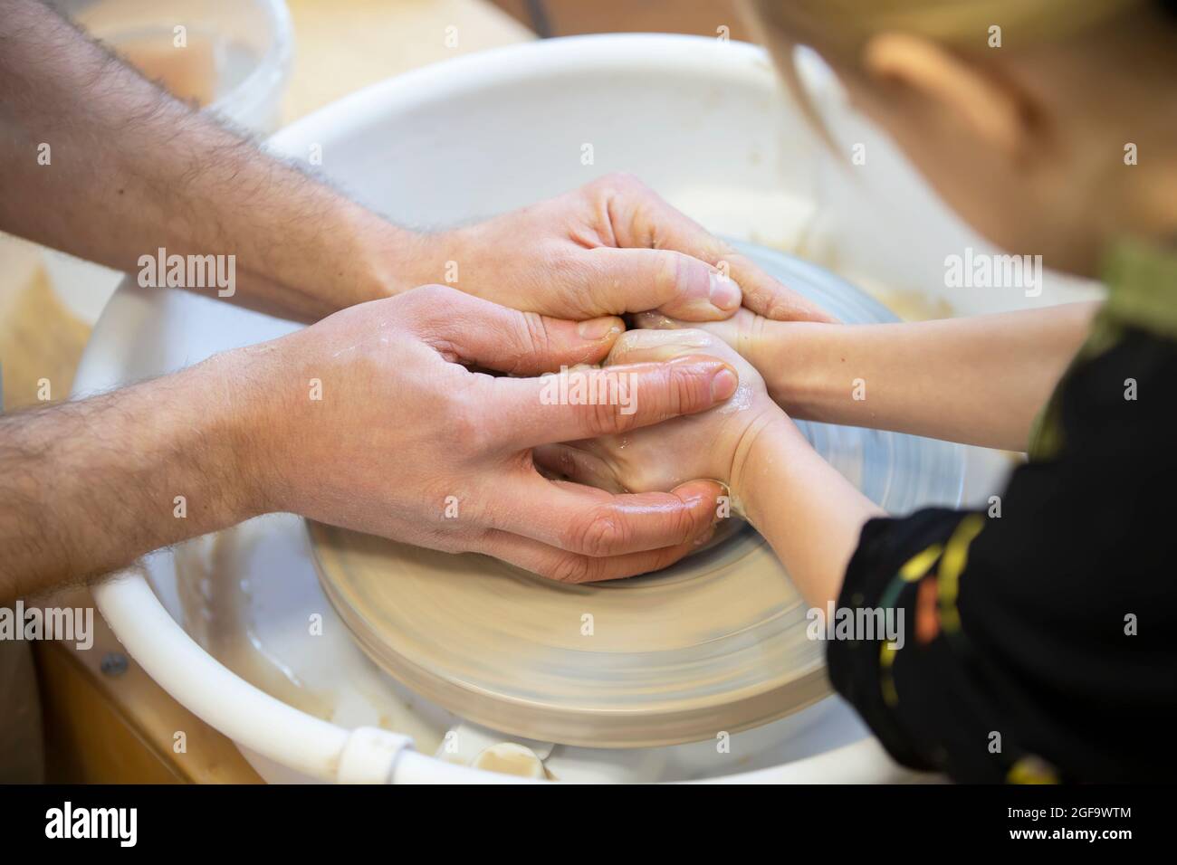 The potter teaches the craft to the child. Closeup of a potter's hands