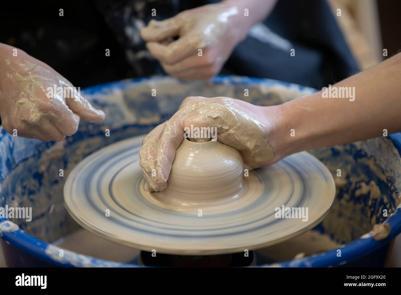 The potter teaches the craft to the child. Closeup of a potter's hands