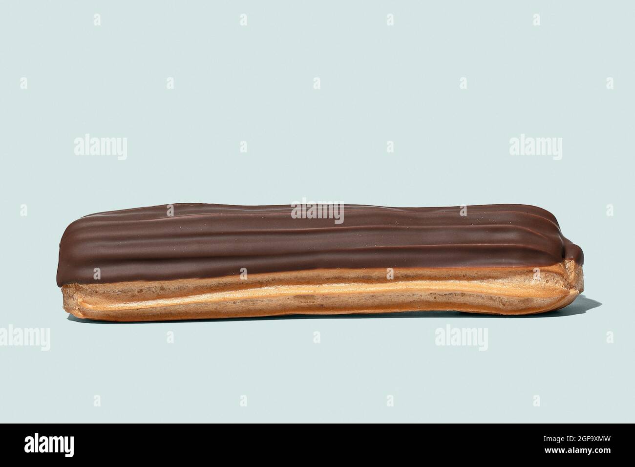 Chocolate eclair on light blue background isolated Stock Photo