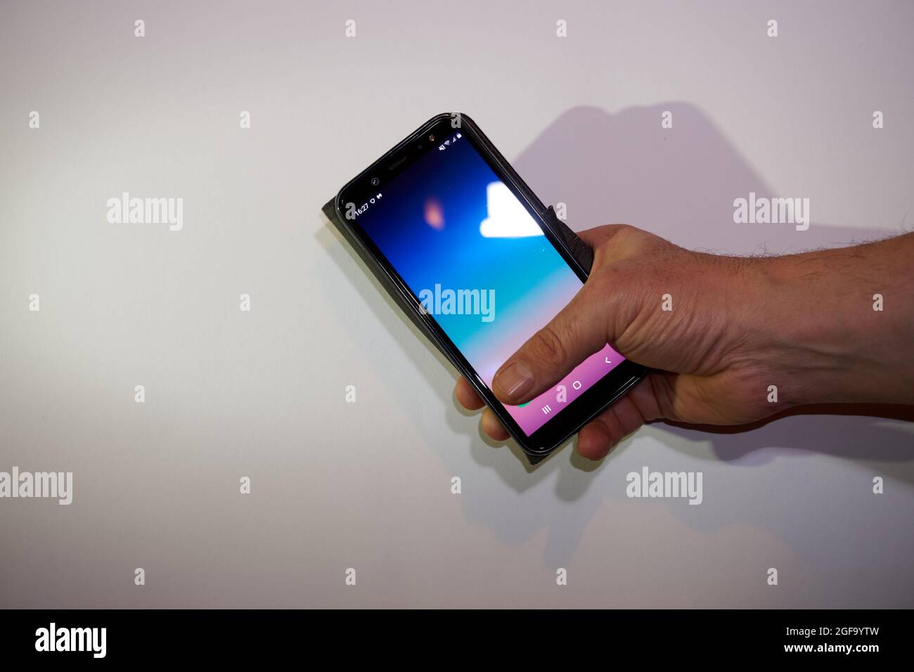 a hand of a man holding smartphone white background isolated Stock ...