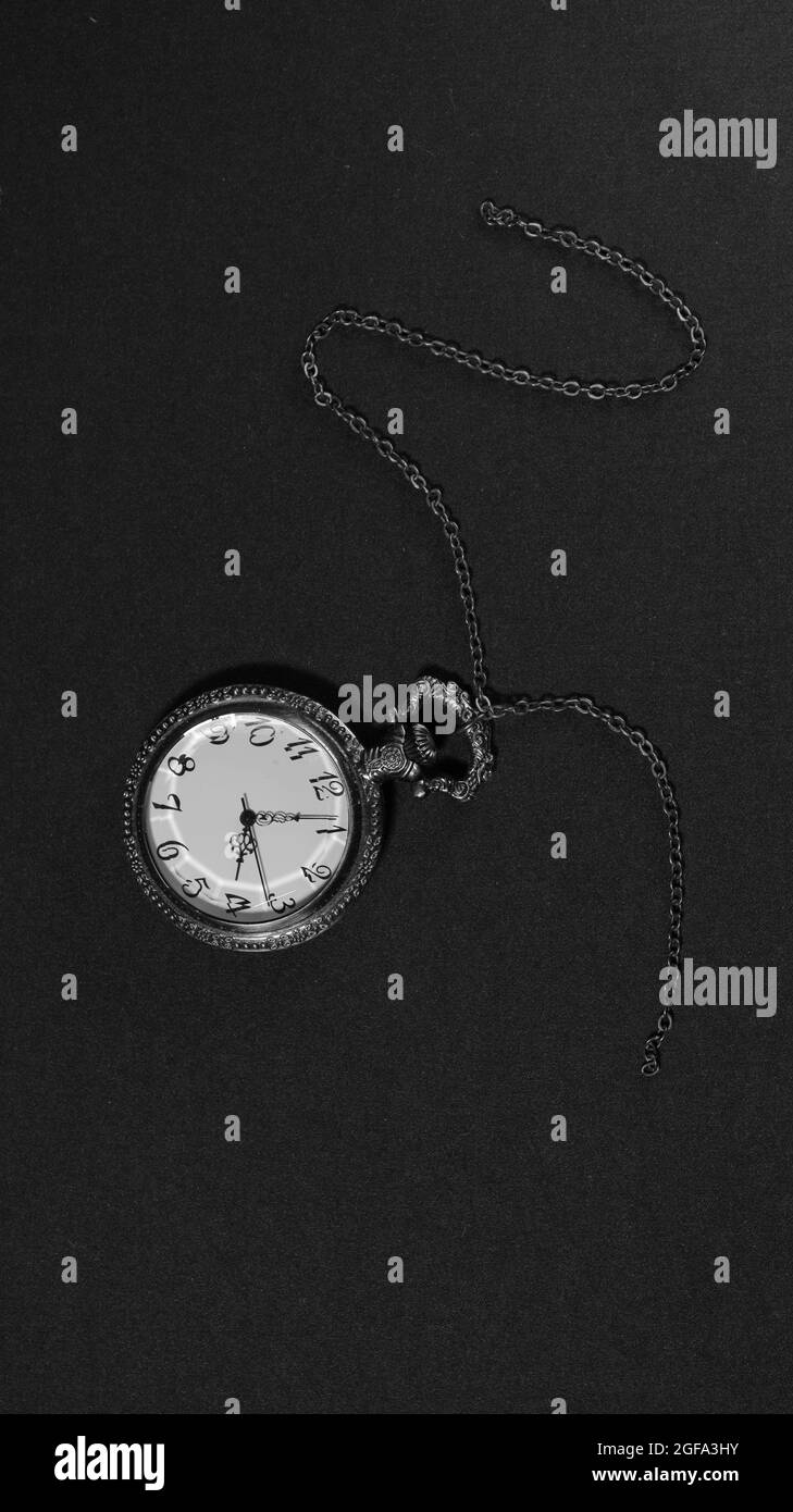 Antique pocket watch with chain, photographed in black and white Stock