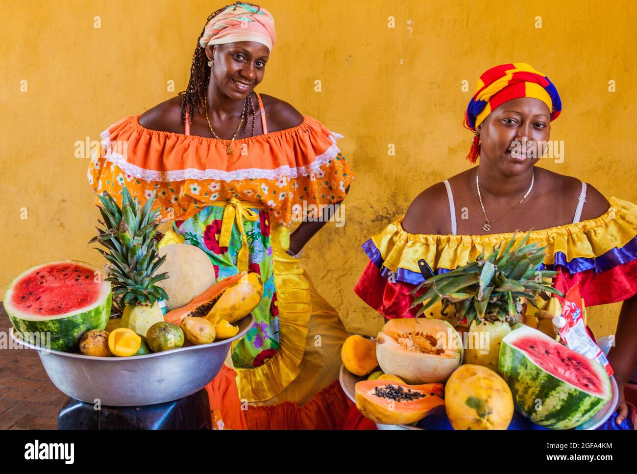 CARTAGENA DE INDIAS, COLOMBIA - AUG 28, 2015: Women wearing traditional costume sell fruits in the center of Cartagena. Stock Photo