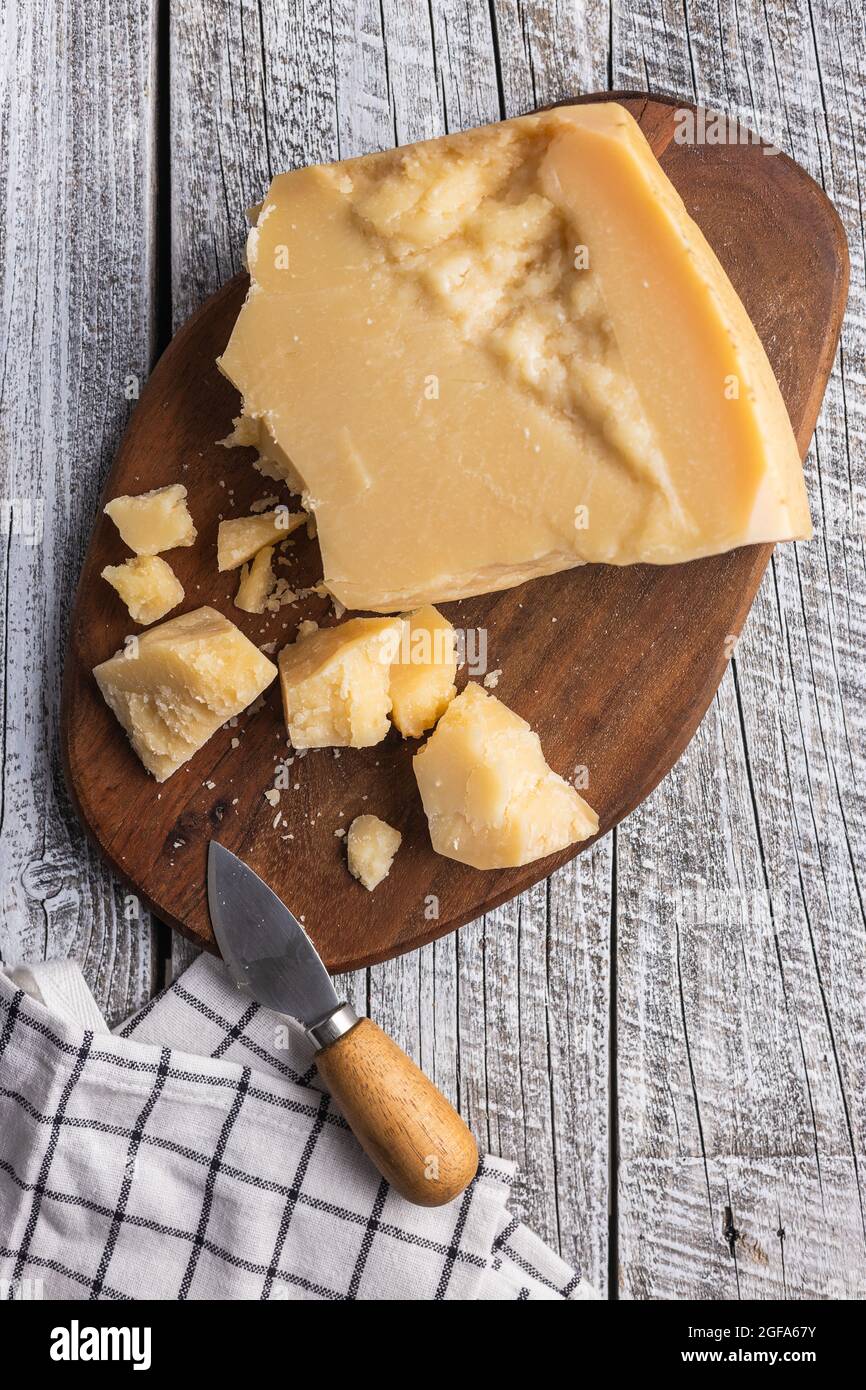 Pieces of italian parmesan cheese. Block of parmesan on wooden table
