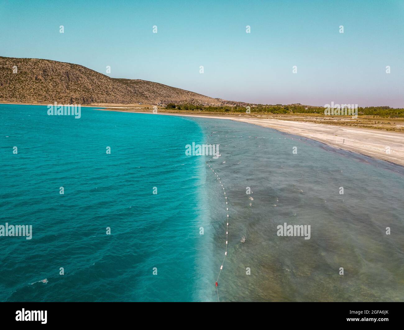 Landscape of a beach surrounded by the sea and hills covered in ...