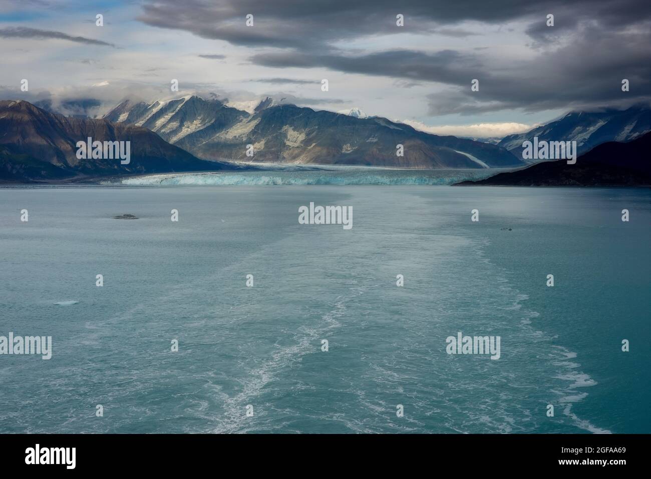 An Illustration of the wake of a cruise ship sailing away from Hubbard Glacier with a view of the glacier and mountains. Stock Photo