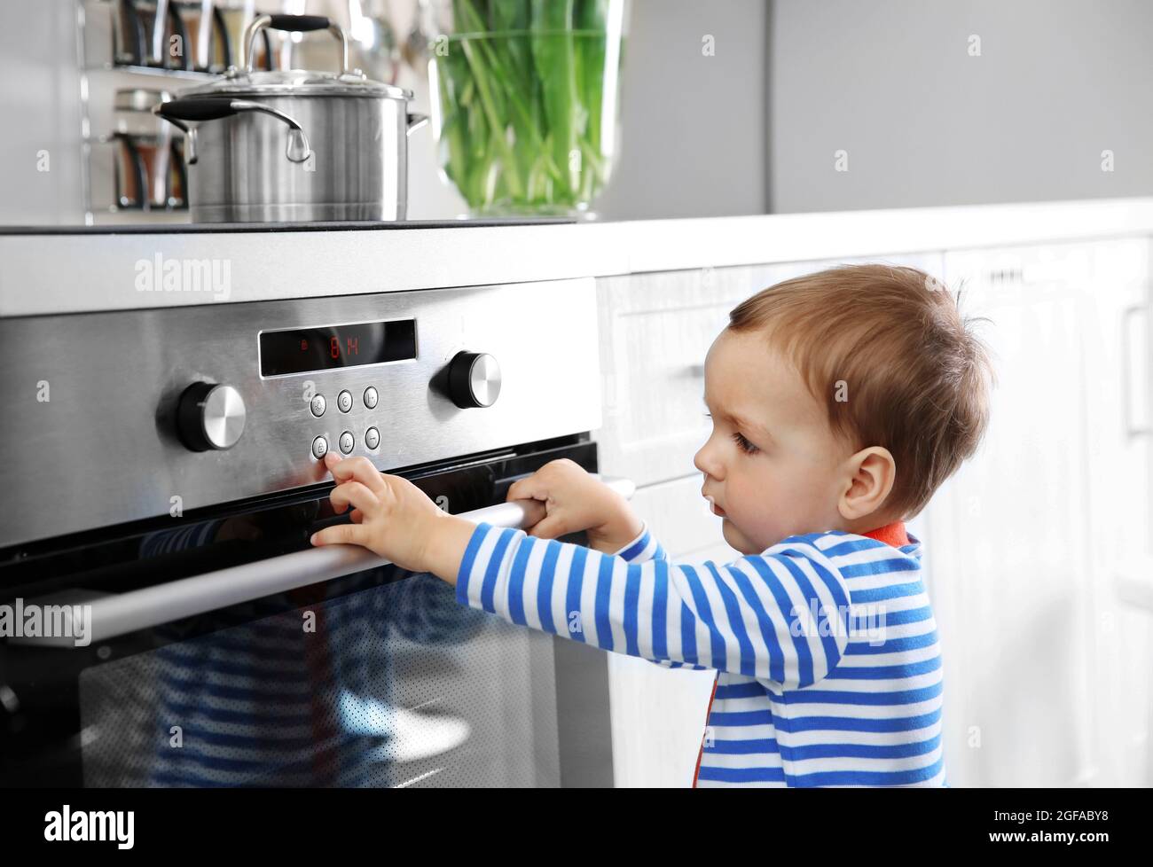 Little child playing with electric stove in the kitchen Stock Photo Alamy