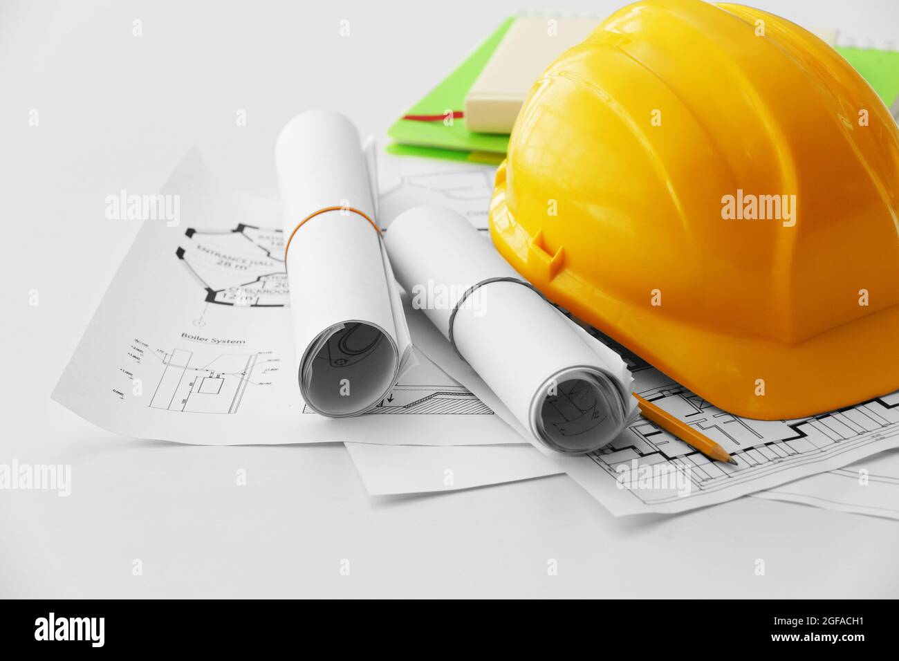 Yellow helmet on the table with blueprints Stock Photo - Alamy