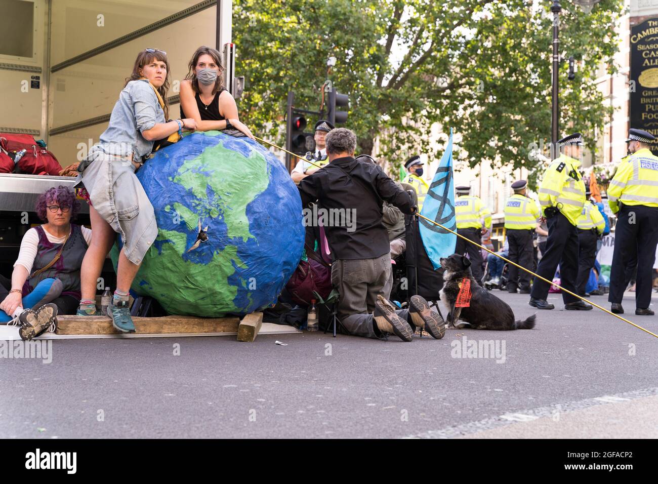 Cambridge Circus, London, UK. 24th August 2021. Climate change protesters from Extinction Rebellion sitting at Cambridge Circus , blocking Charing Cross road along the way to Trafalgar Square. Credit: Xiu Bao/Alamy Live News Stock Photo