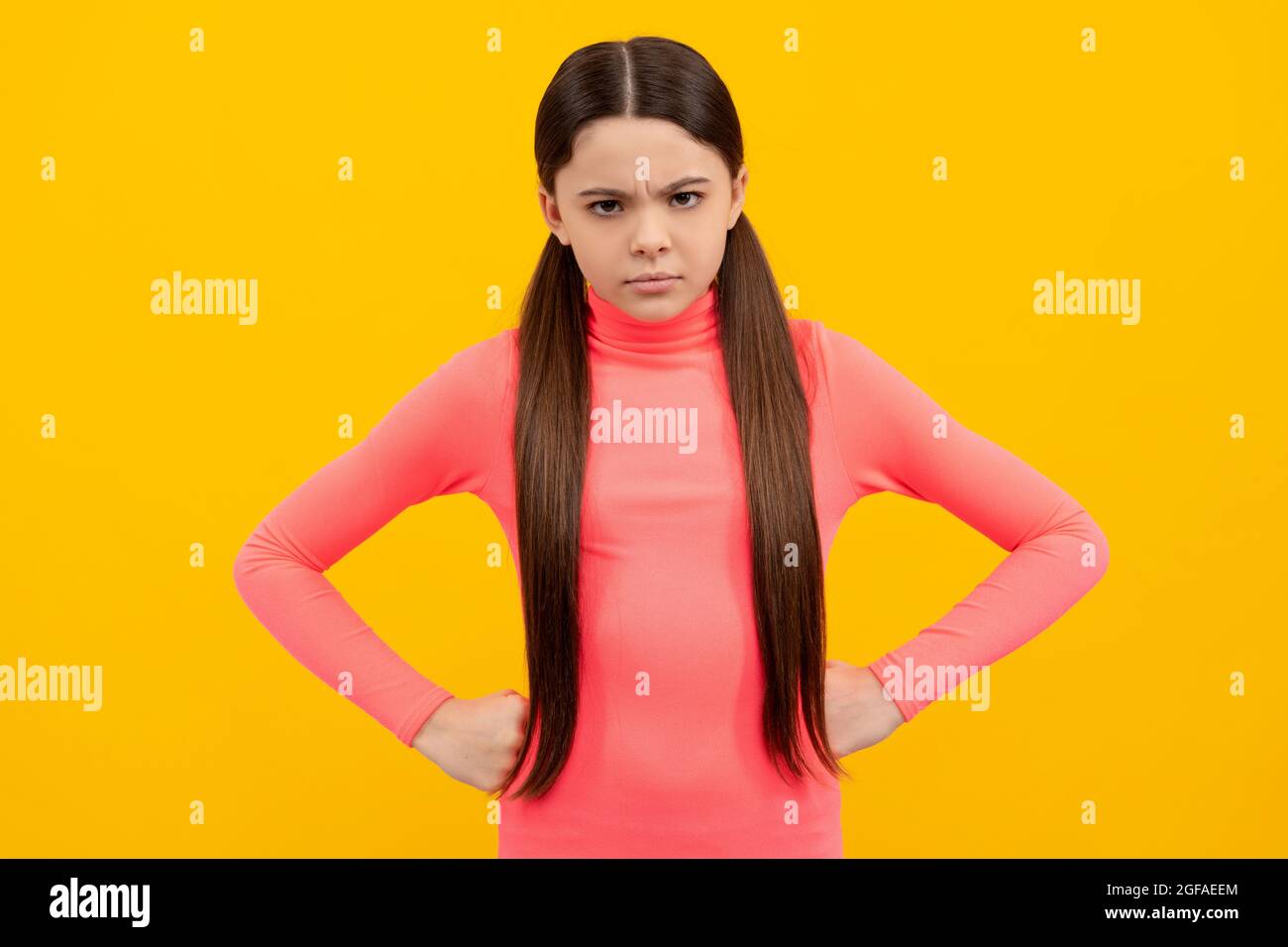 angry kid with long hair on yellow background, anger Stock Photo