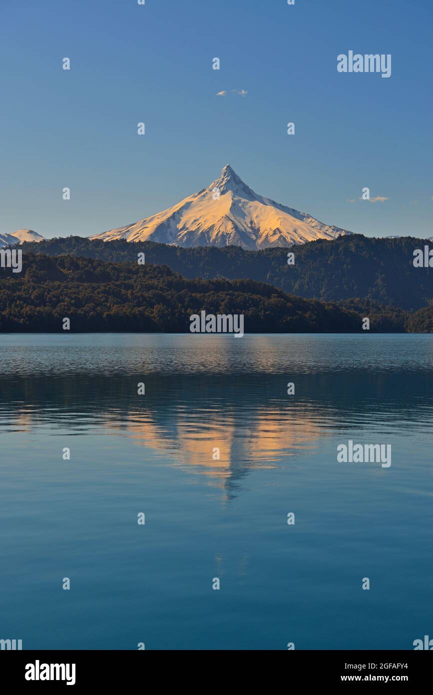 Reflection of the Puntiagudo volcano at sunset by All Saints Lake, Chile. Stock Photo