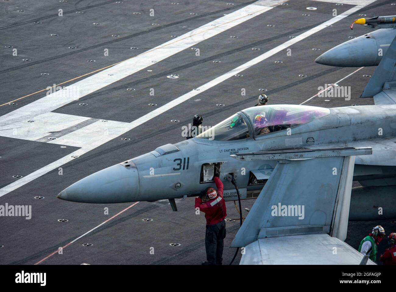 Arabian Sea, United States. 24th Aug, 2021. U.S. Navy sailors prepare a F/A-18E Super Hornet fighter jet, attached to the Eagles of Strike Fighter Squadron 115, for take off on the flight deck of aircraft carrier USS Ronald Reagan August 24, 2021 in the Arabian Sea. Credit: Planetpix/Alamy Live News Stock Photo