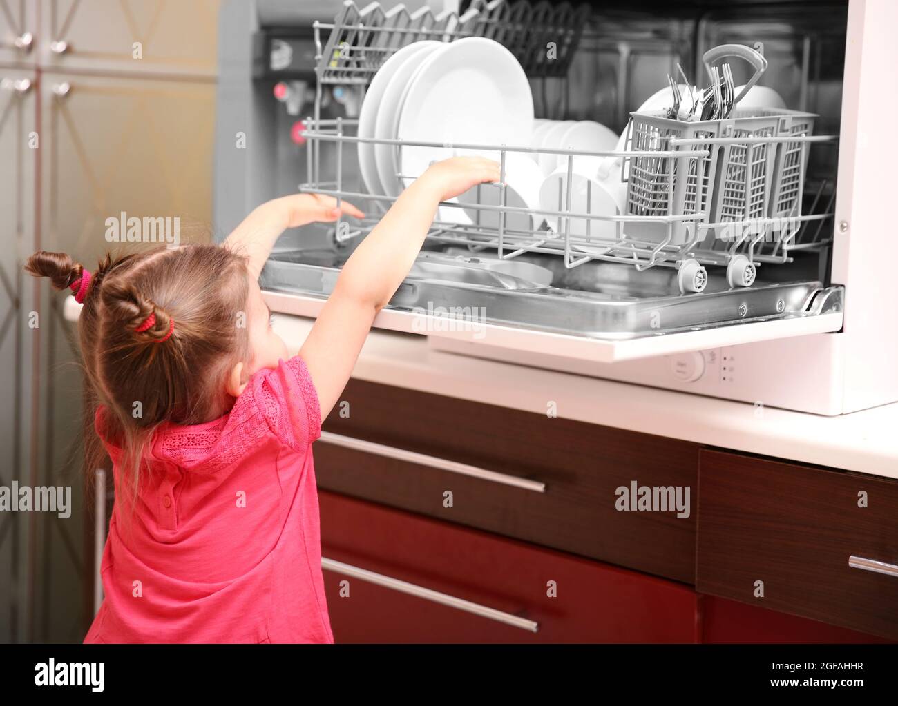 Little girl playing with dishwasher in kitchen Stock Photo Alamy