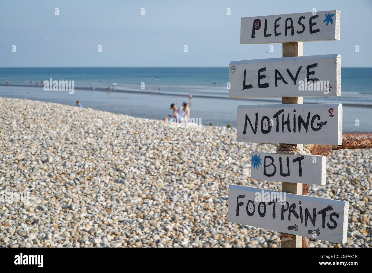 East Wittering, Sussex, UK, 23 August 2021: A folksy style sign reads 'Please leave nothing but footprints' at the top of the beach, reminding tourist Stock Photo