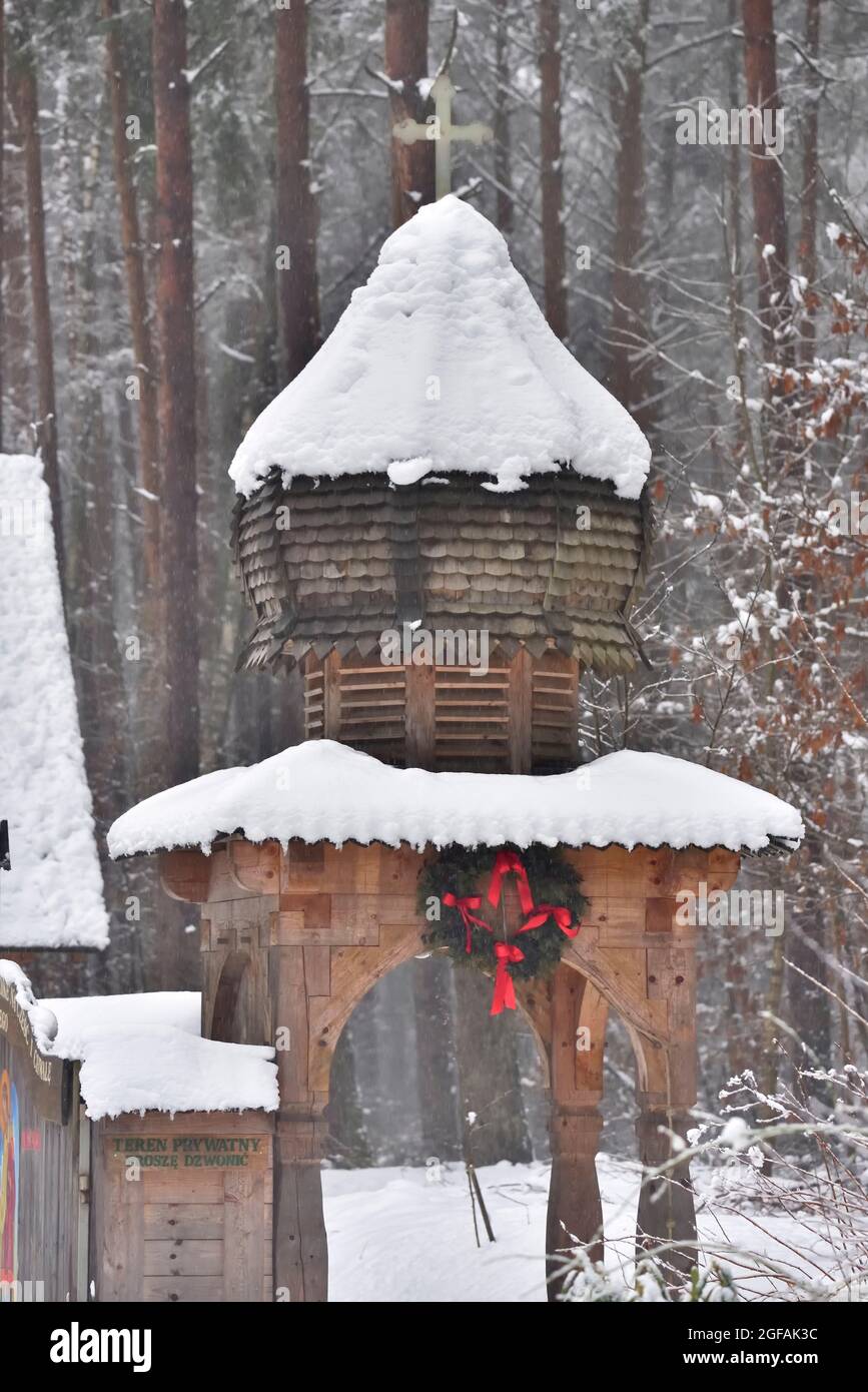 a wooden church in the forest, covered with snow in winter . entrance ...