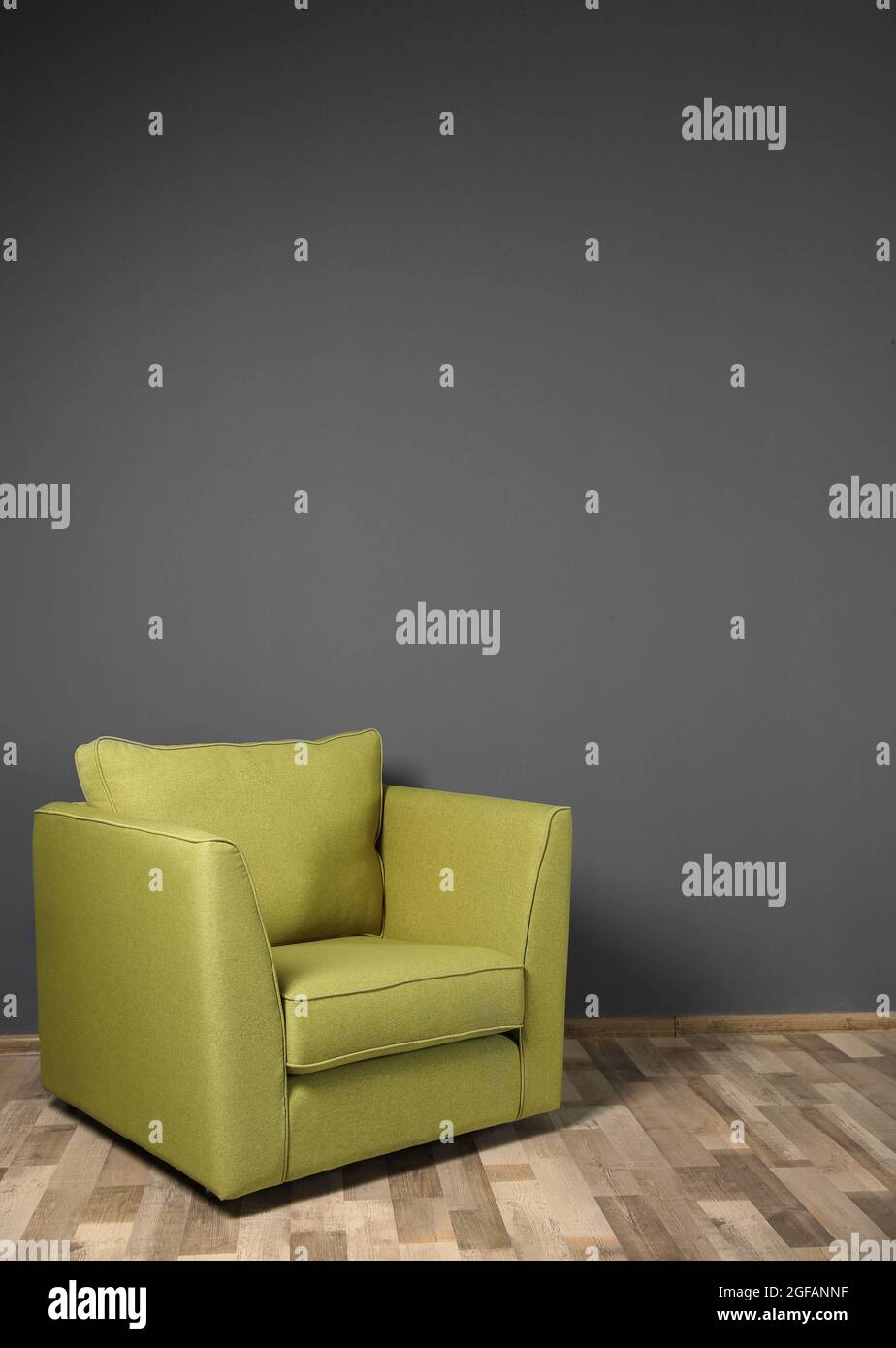 Green armchair on dark grey wall background Stock Photo Alamy