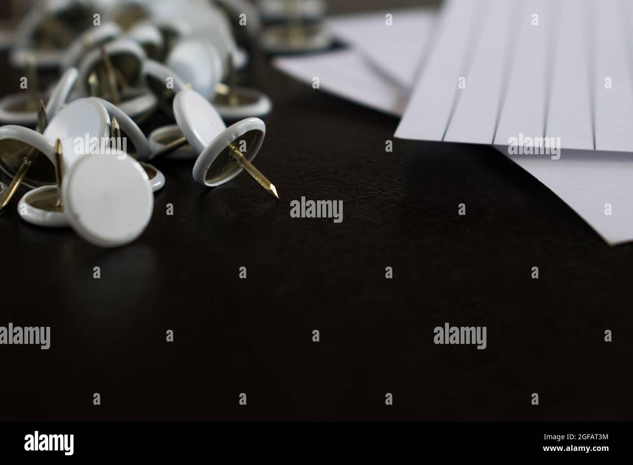 Office stuff like some sheets of paper and other white stationery on a black wooden table Stock Photo