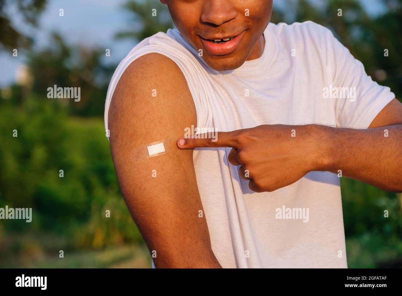 Young smiling African American man showing hand with adhesive plaster  Stock Photo