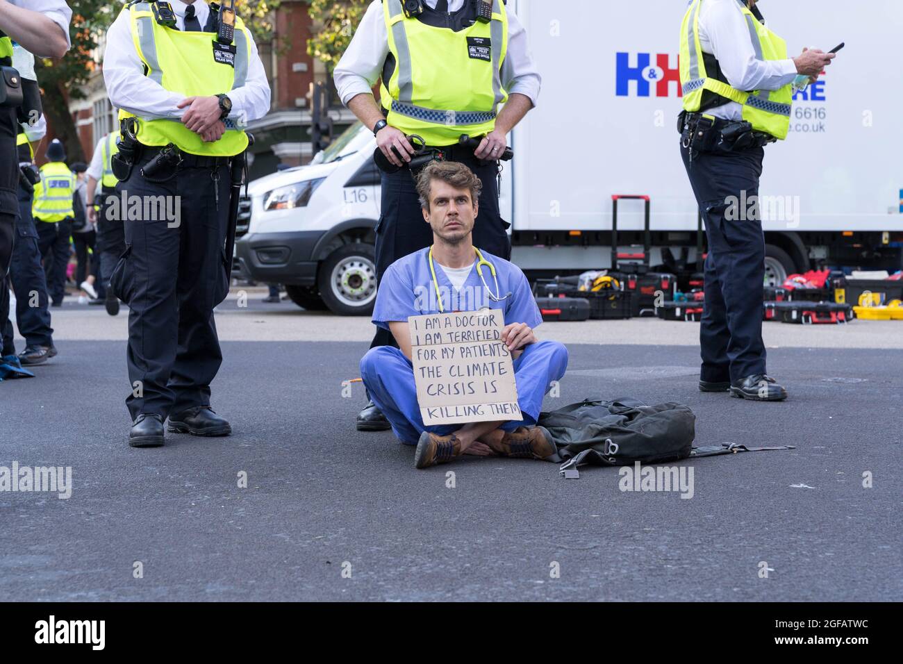 Cambridge Circus, London, UK. 24th August 2021. Climate change protesters from Extinction Rebellion siting at Cambridge Circus , blocking Charing Cross road along the way to Trafalgar Square. Credit: Xiu Bao/Alamy Live News Stock Photo
