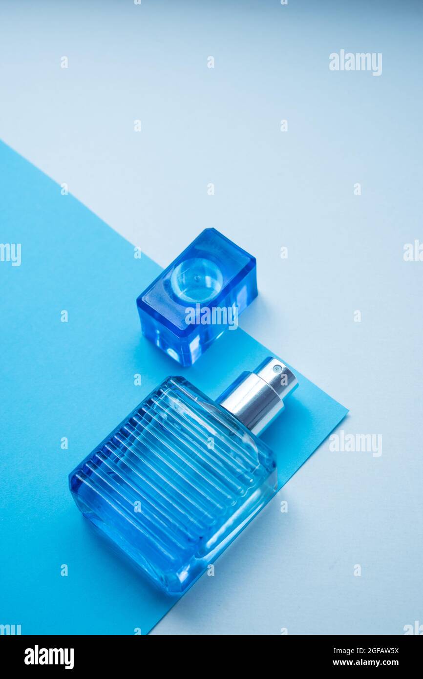 Little blue glass fragrance bottle on a blue and white background with copy space Stock Photo