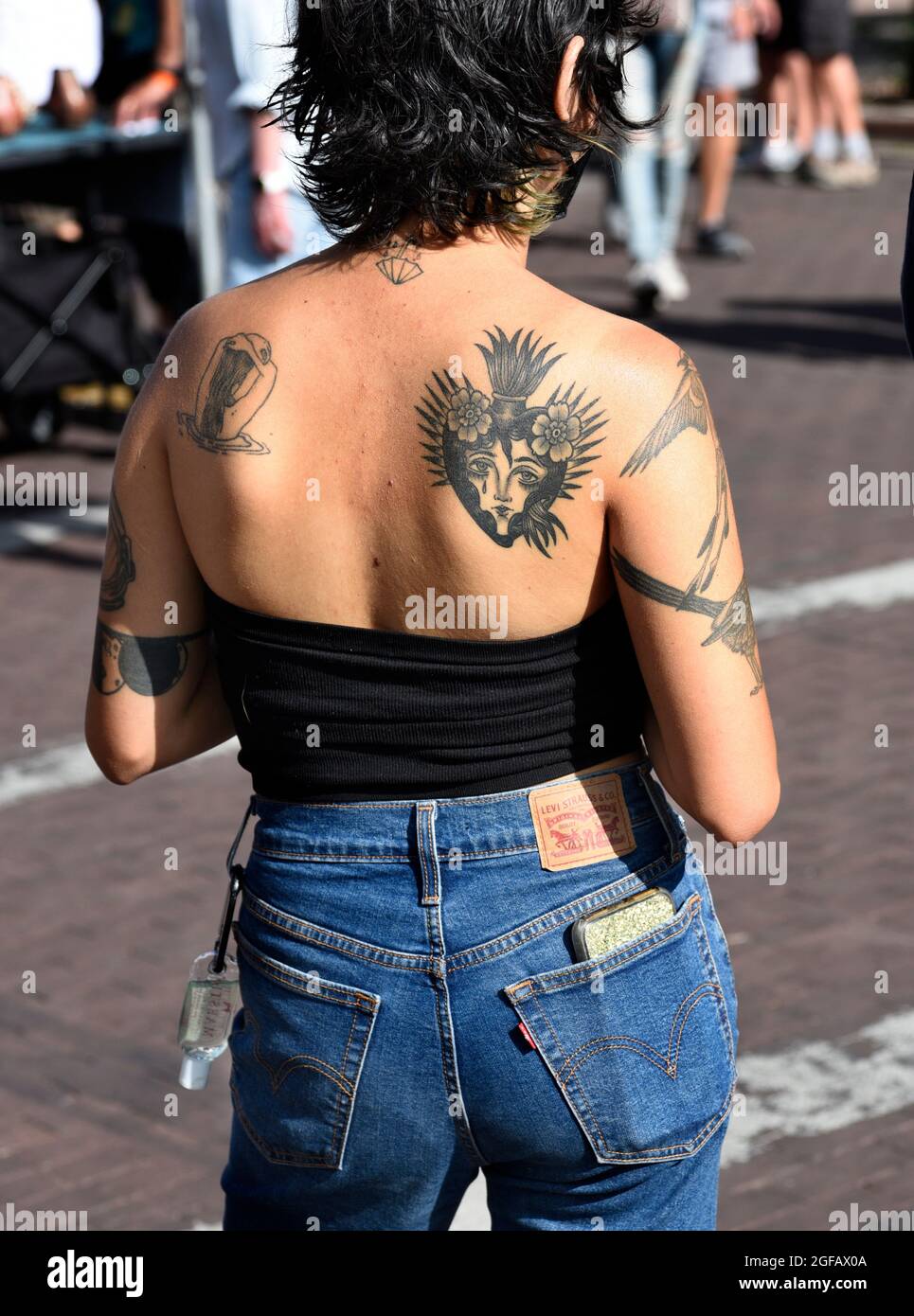 A young woman with a Sacred Heart tattoo on her back visits an outdoor art show in Santa Fe, New Mexico. Stock Photo