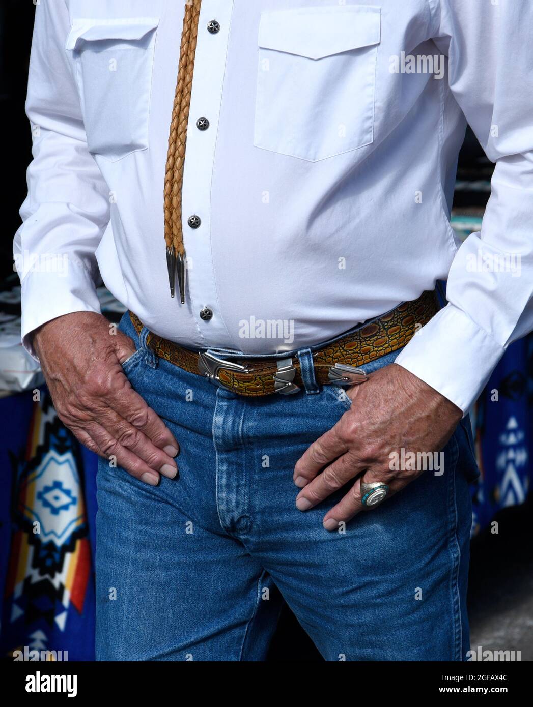 A well-dressed senior man wearing American western attire visits an outdoor art show in Santa Fe, New Mexico. Stock Photo