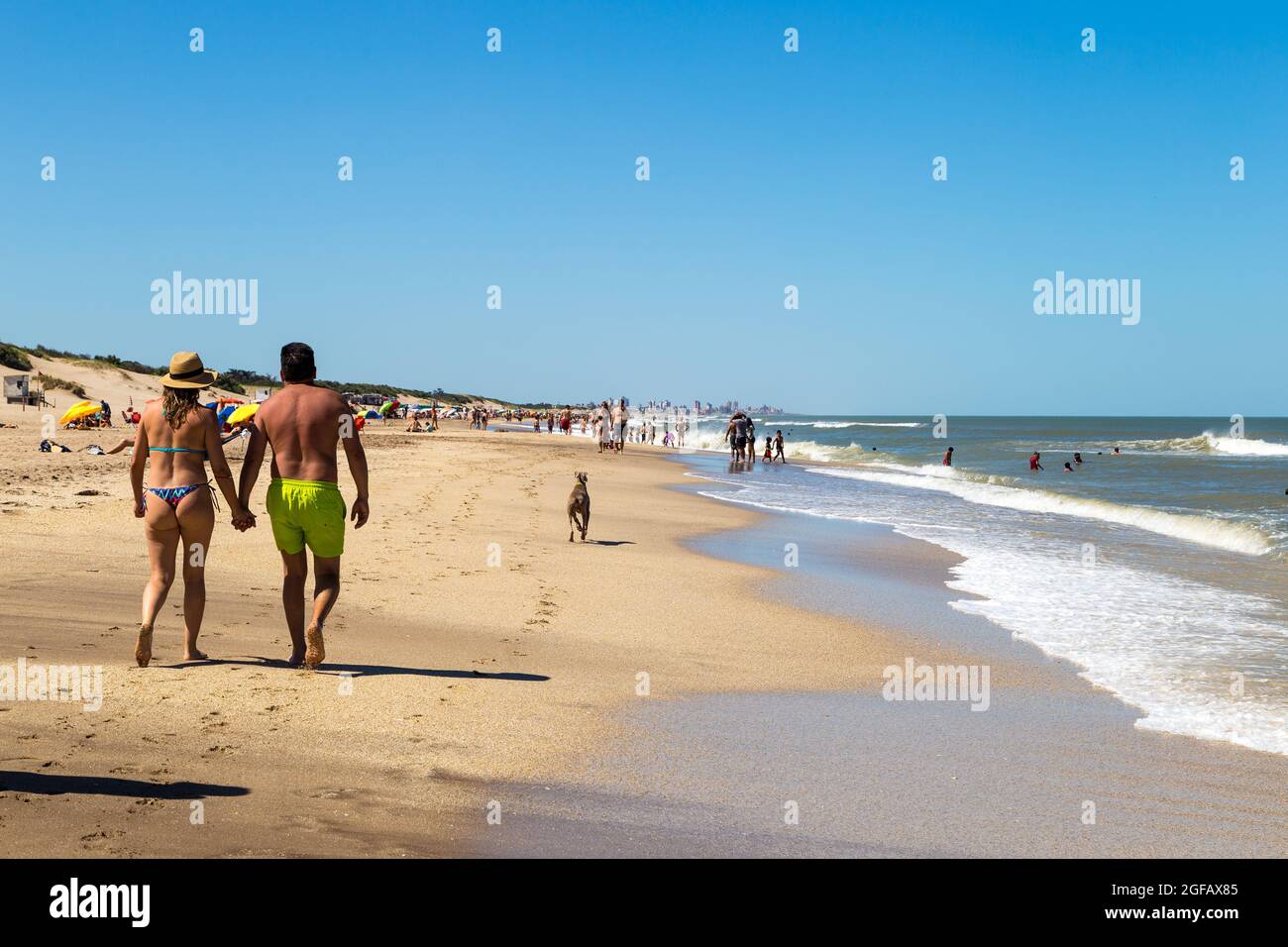 MAR DE LAS PAMPAS, BUENOS AIRES, ARGENTINA. A couple walking on the sand in  foreground. The people enjoying the beach in a sunny day of summer Stock  Photo - Alamy