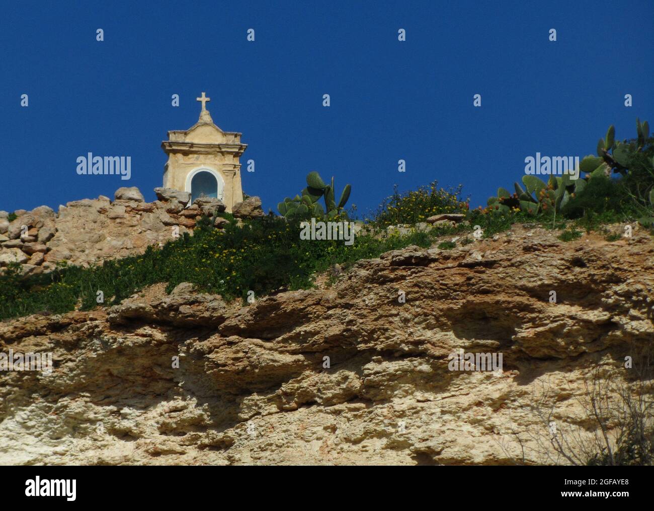 MGARR, MALTA - Feb 09, 2014: A limestone niche, with a statue of the Virgin Mary, on top of a cliff in the countryside of Malta Stock Photo