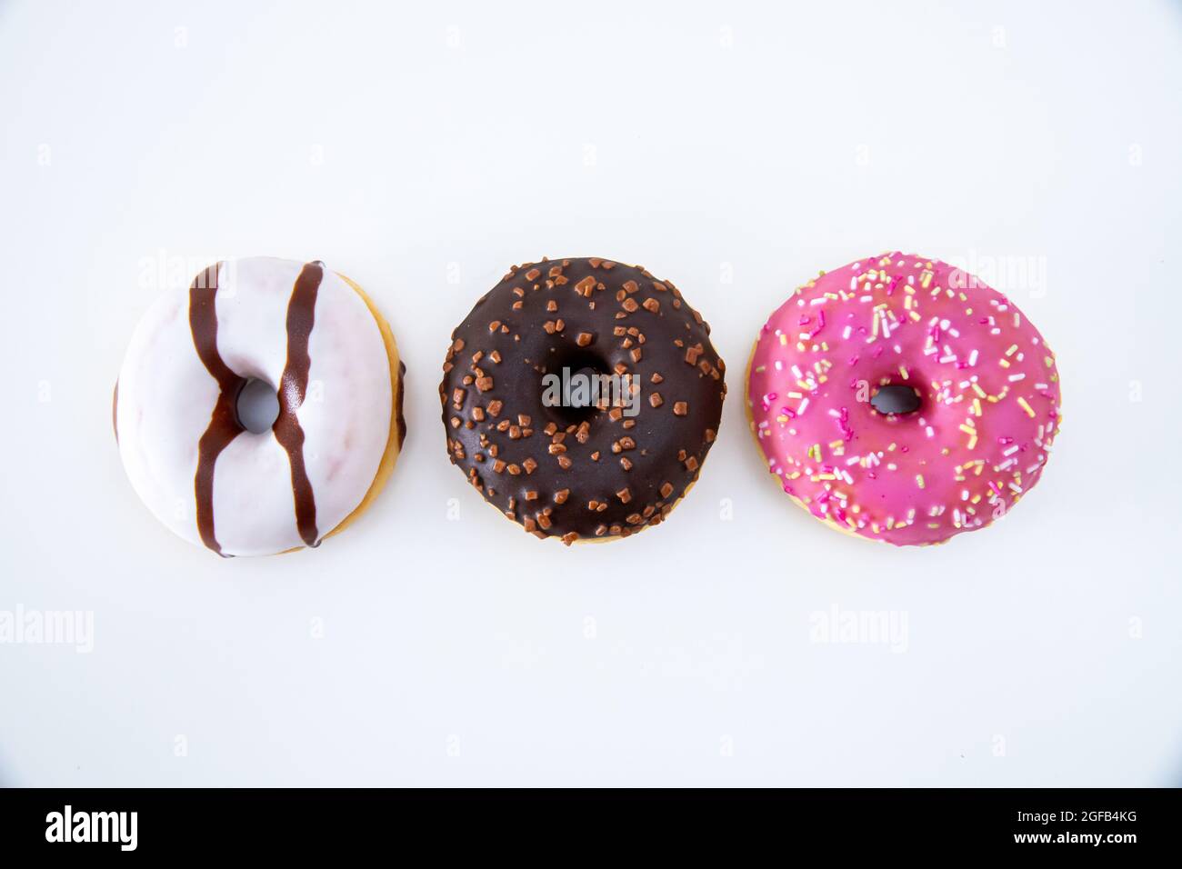 Top view closeup of three delicious colorful donuts on an isolated ...