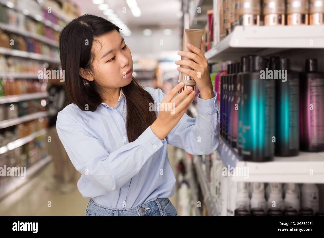 Asian female buying hair conditioner Stock Photo Alamy