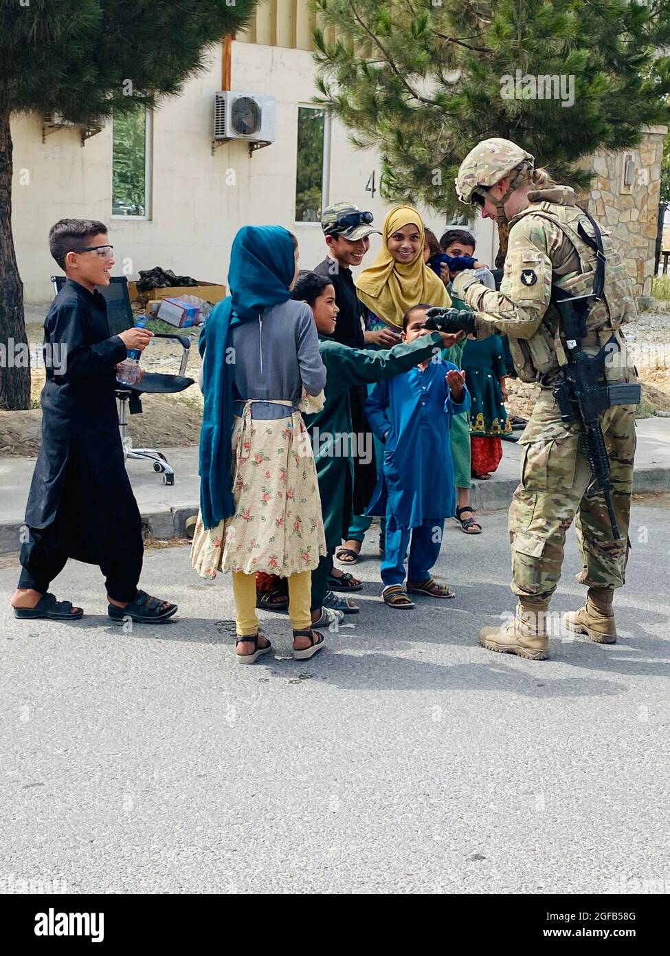 1st Lt. Michelle Jaeger, a platoon leader with the Minnesota National Guard's A Company, 1st Combined Arms Battalion, 194th Armor Regiment, interacts with Afghan children as part of operations at Hamid Karzai International Airport on August 21, 2021.   Minnesota Soldiers are providing humanitarian assistance to U.S. citizens, special immigrant visa holders, and their families.   Approximately 1,100 Soldiers from Task Force 1-194 deployed to the Middle East in early 2021 for a nine-month mission in support of Operation Spartan Shield. While deployed, the Soldiers assumed responsibilities within Stock Photo