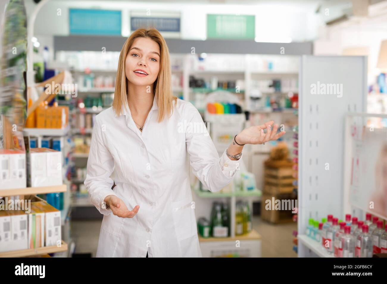 Ordinary woman pharmacist showing assortment of drugs in pharmacy Stock Photo