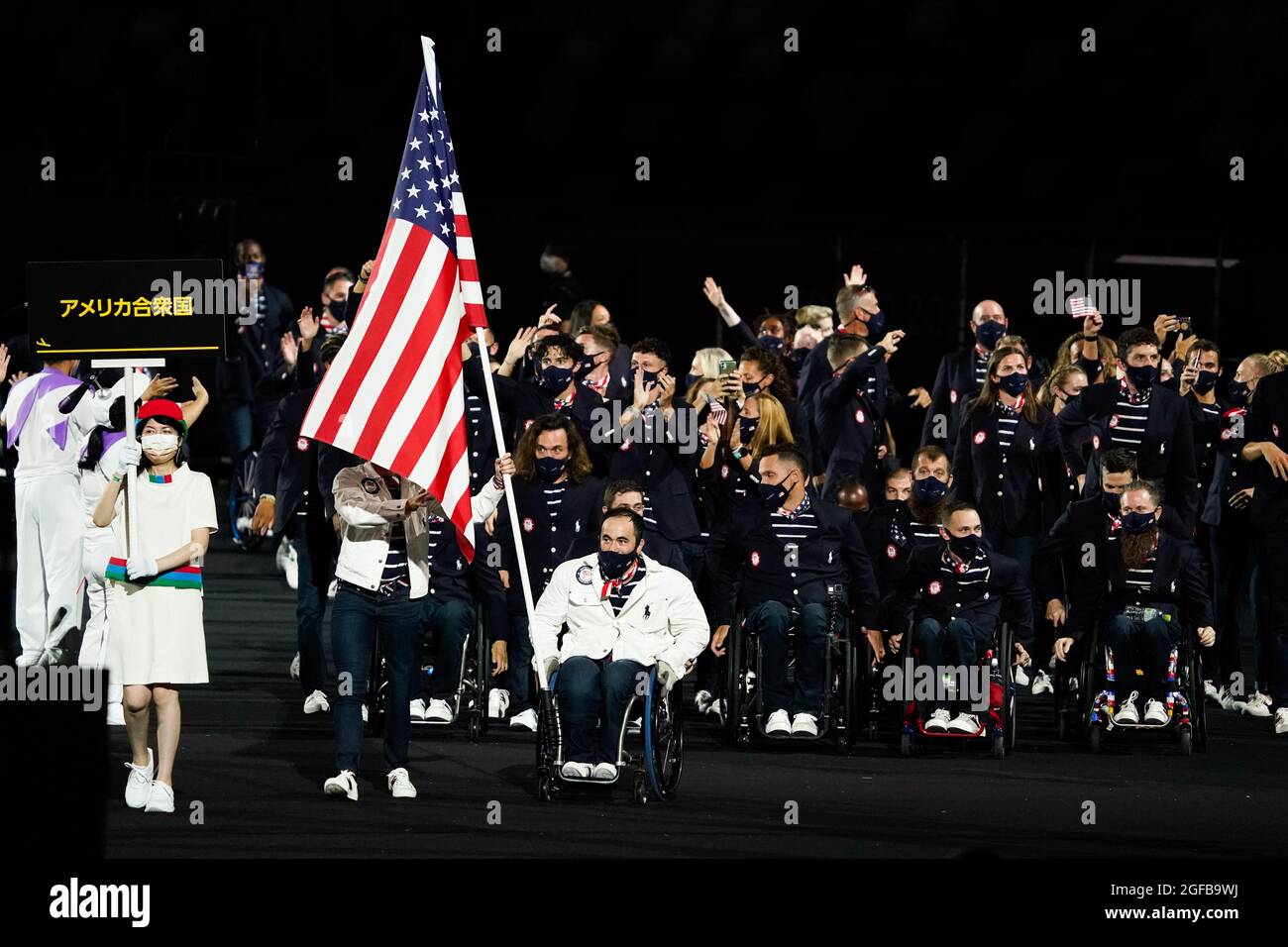 Melissa Stockwell and Chuck Aoki carry the United States flag (USA) as