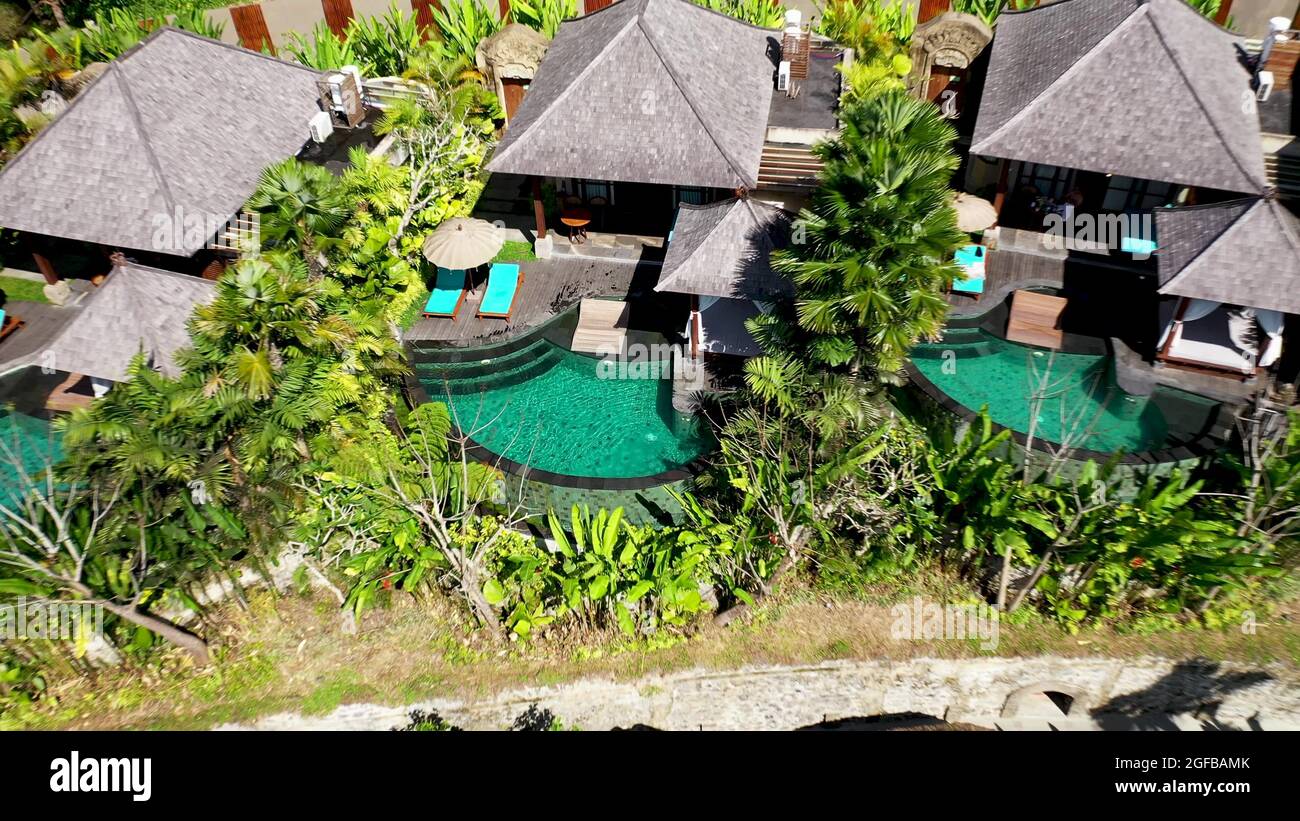 Drone aerial view of luxury hotel with straw roof villas and pools in ...