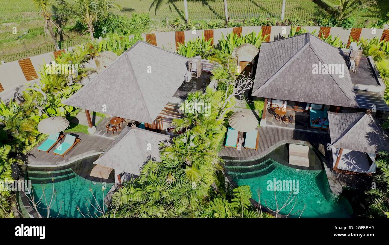 aerial view of luxury hotel with straw roof villas and pools in ...