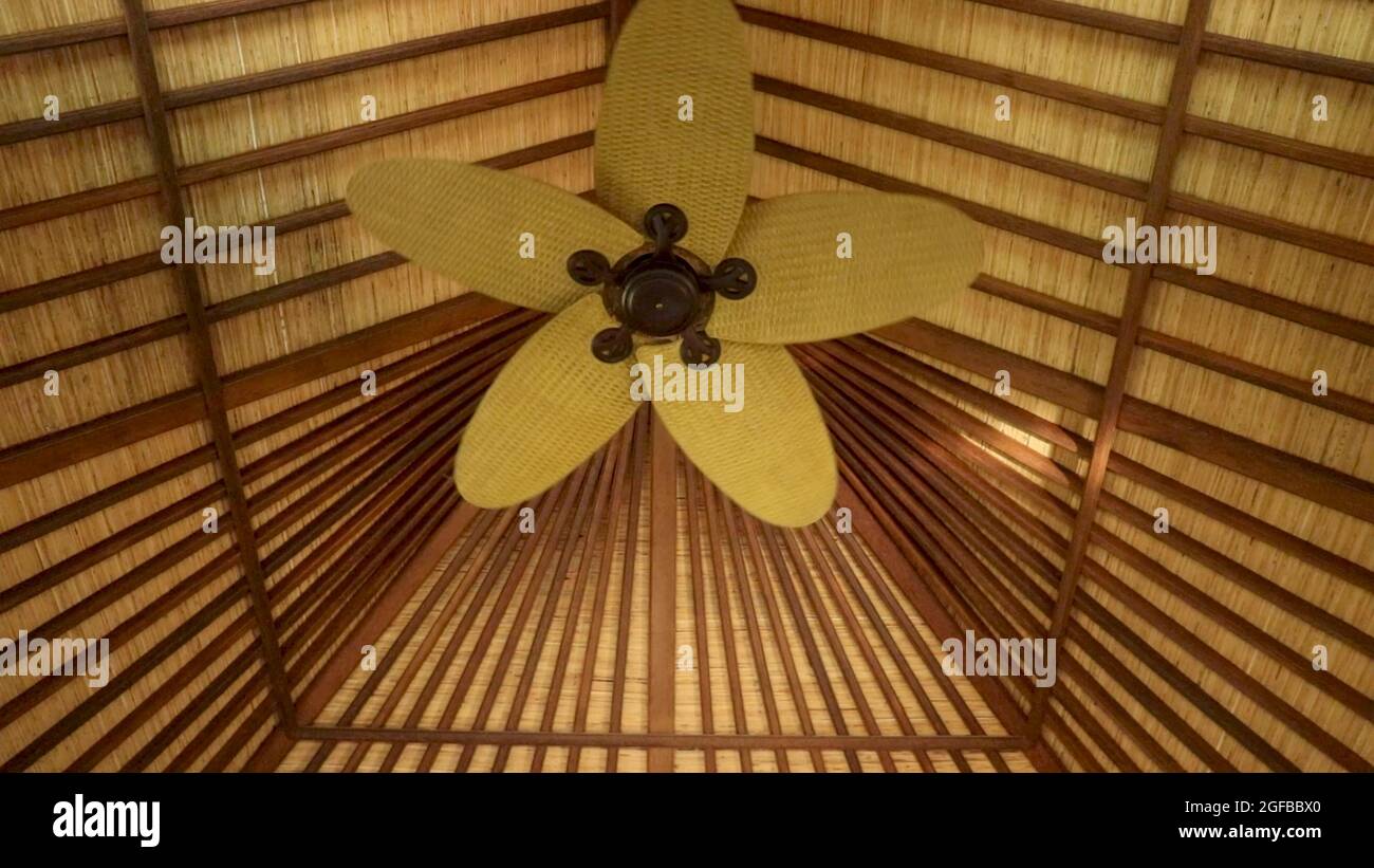 Ceiling fan on wooden roof. Electric ceiling fan rotating slowly and