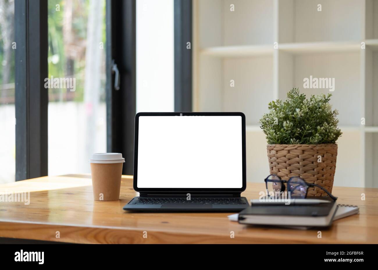 Shot of digital tablet with blank white screen, keyboard, cup of coffee on workspace desk Stock Photo