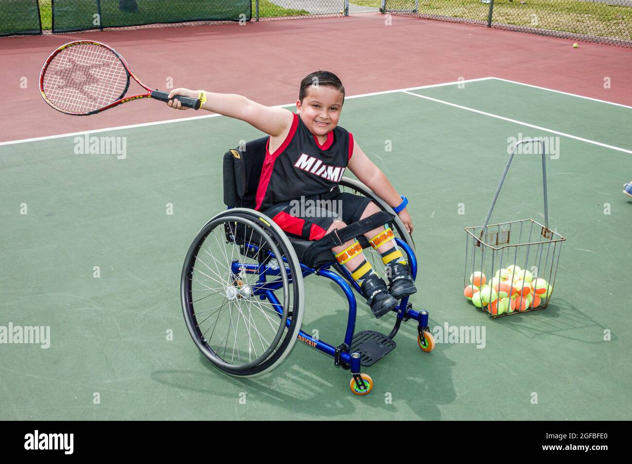 Miami Florida,Tropical Park Paralympic Experience,handicapped disabled tennis court wheelchair Hispanic male boy holding racket, Stock Photo