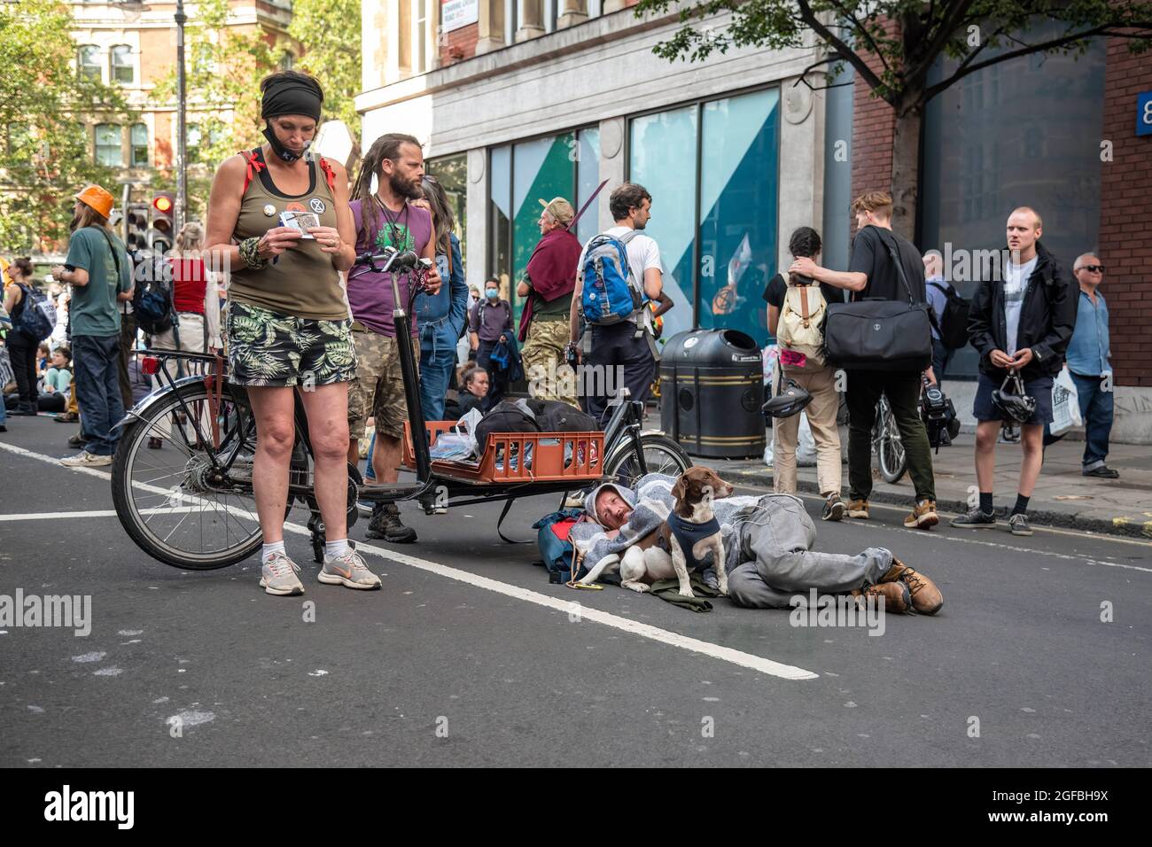 London, UK. 24th Aug, 2021. A protester and his dog lay in the road at Cambridge Circus, during the demonstration.‘The Impossible Rebellion' protest against climate change, global warming, which plans to target the root cause of the climate and ecological crisis and to demand the government divest from fossil fuel companies by Extinction Rebellion. (Photo by Dave Rushen/SOPA Images/Sipa USA) Credit: Sipa USA/Alamy Live News Stock Photo