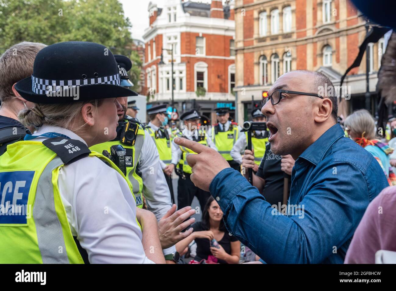London, UK. 24th Aug, 2021. A man tries to get through police lines and argues with officers, during the demonstration.‘The Impossible Rebellion' protest against climate change, global warming, which plans to target the root cause of the climate and ecological crisis and to demand the government divest from fossil fuel companies by Extinction Rebellion. (Photo by Dave Rushen/SOPA Images/Sipa USA) Credit: Sipa USA/Alamy Live News Stock Photo