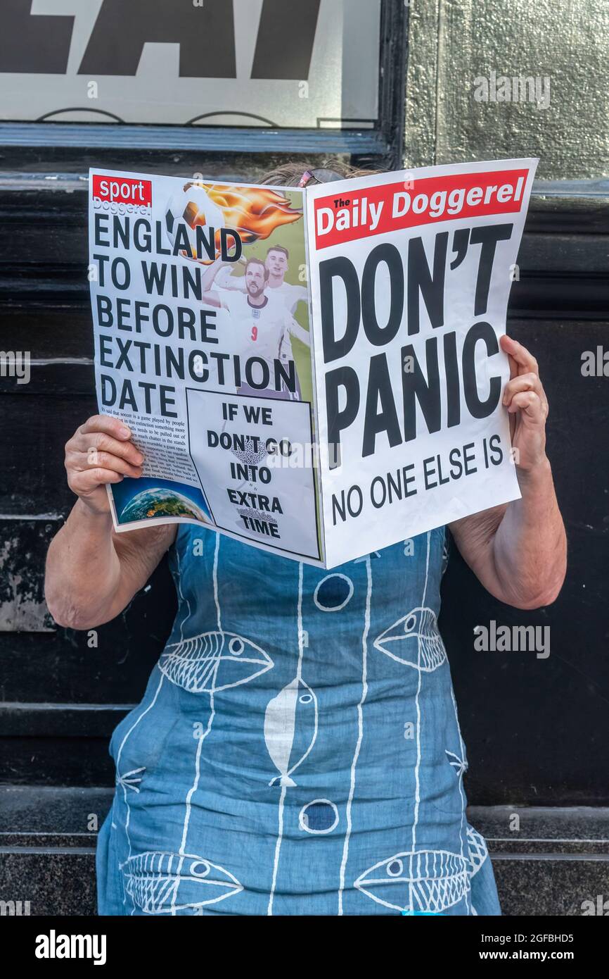 London, UK. 24th Aug, 2021. A protester holds a fake newspaper with the words 'Don't Panic' during the demonstration.‘The Impossible Rebellion' protest against climate change, global warming, which plans to target the root cause of the climate and ecological crisis and to demand the government divest from fossil fuel companies by Extinction Rebellion. (Photo by Dave Rushen/SOPA Images/Sipa USA) Credit: Sipa USA/Alamy Live News Stock Photo