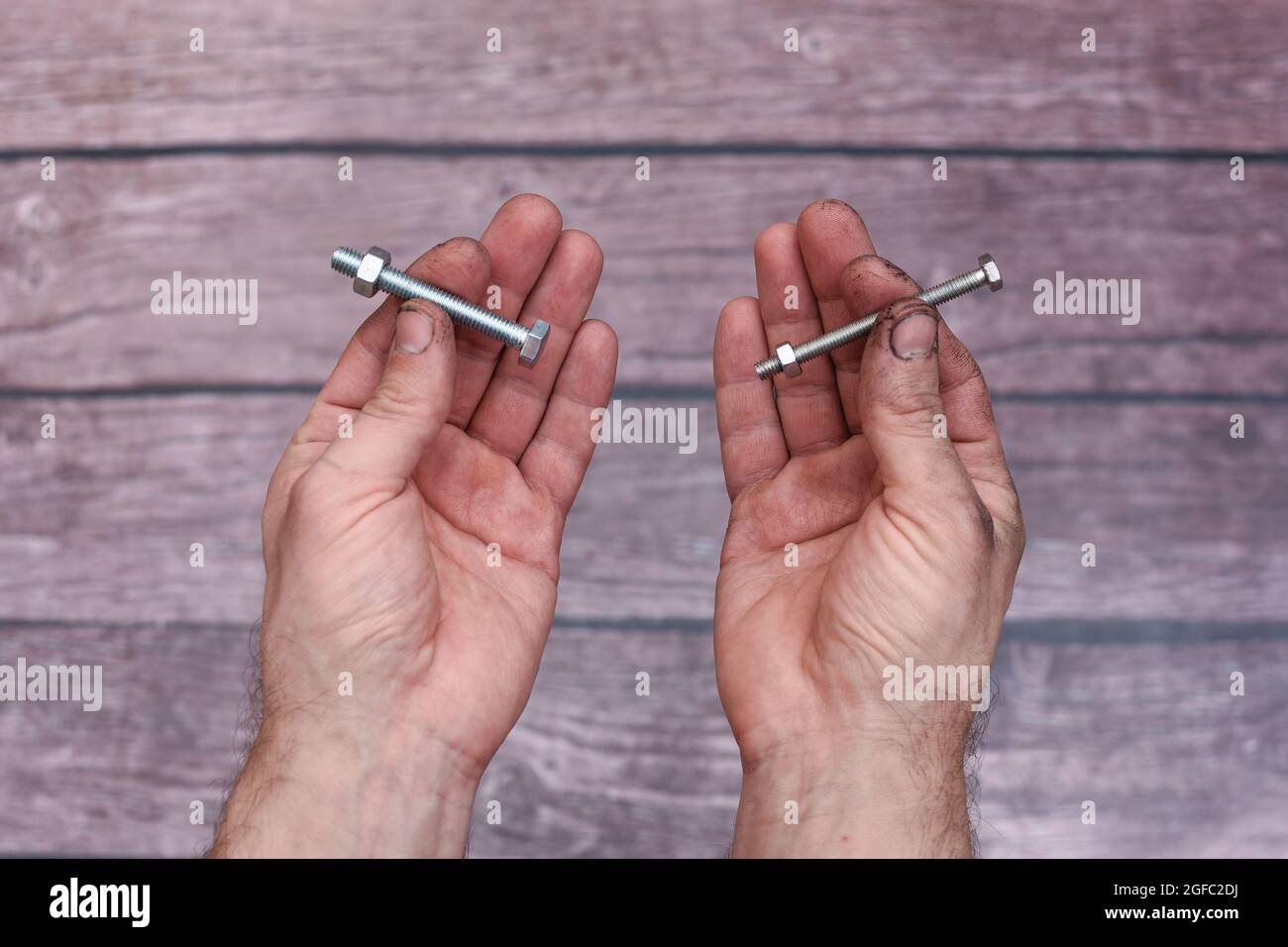 the man shows two bolts with nuts Stock Photo Alamy