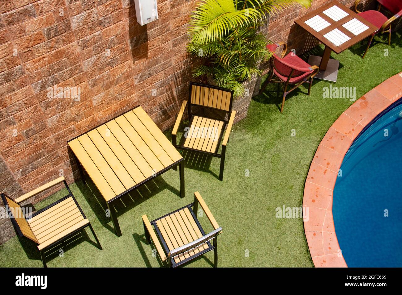 Small swimming pool in private luxury residence villa, with tables and chairs around, decorative plants and floating rings Stock Photo