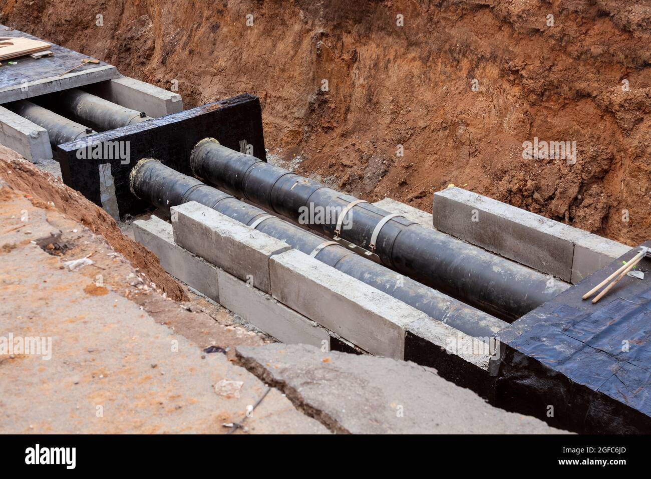 Insulated pipes in the trench. Water main reconstruction and replacement. Stock Photo