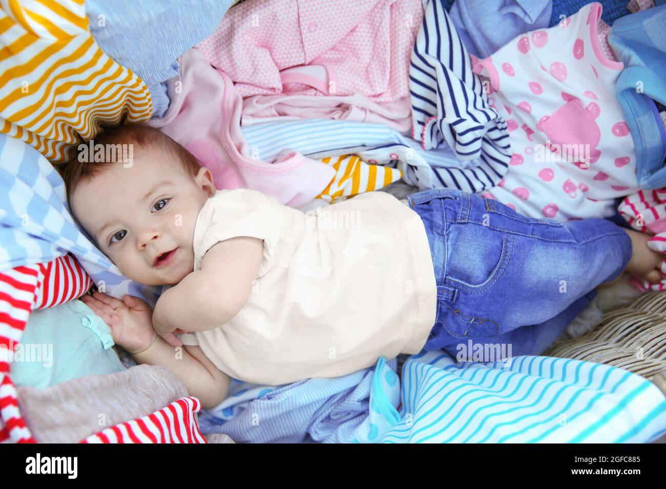 Cute baby boy in wicker basket with clothes Stock Photo - Alamy