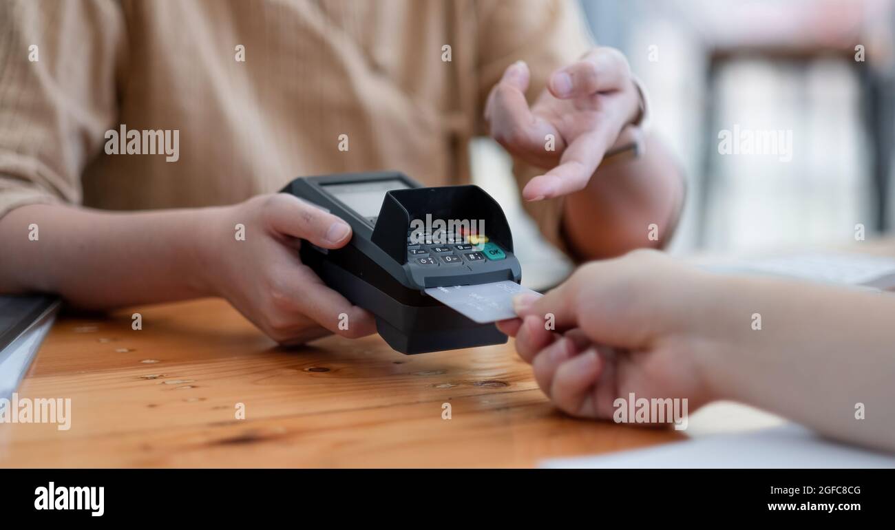 Customer using credit card for purchase to waitress EDC at cashier, Credit card payment concept Stock Photo