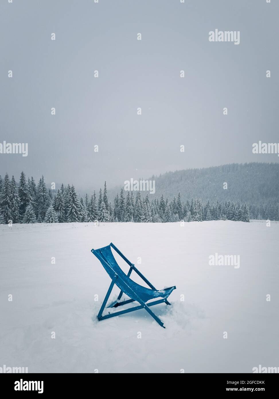 Sunbed type chair on the top of a mountain in a snowy winter day. Fir
