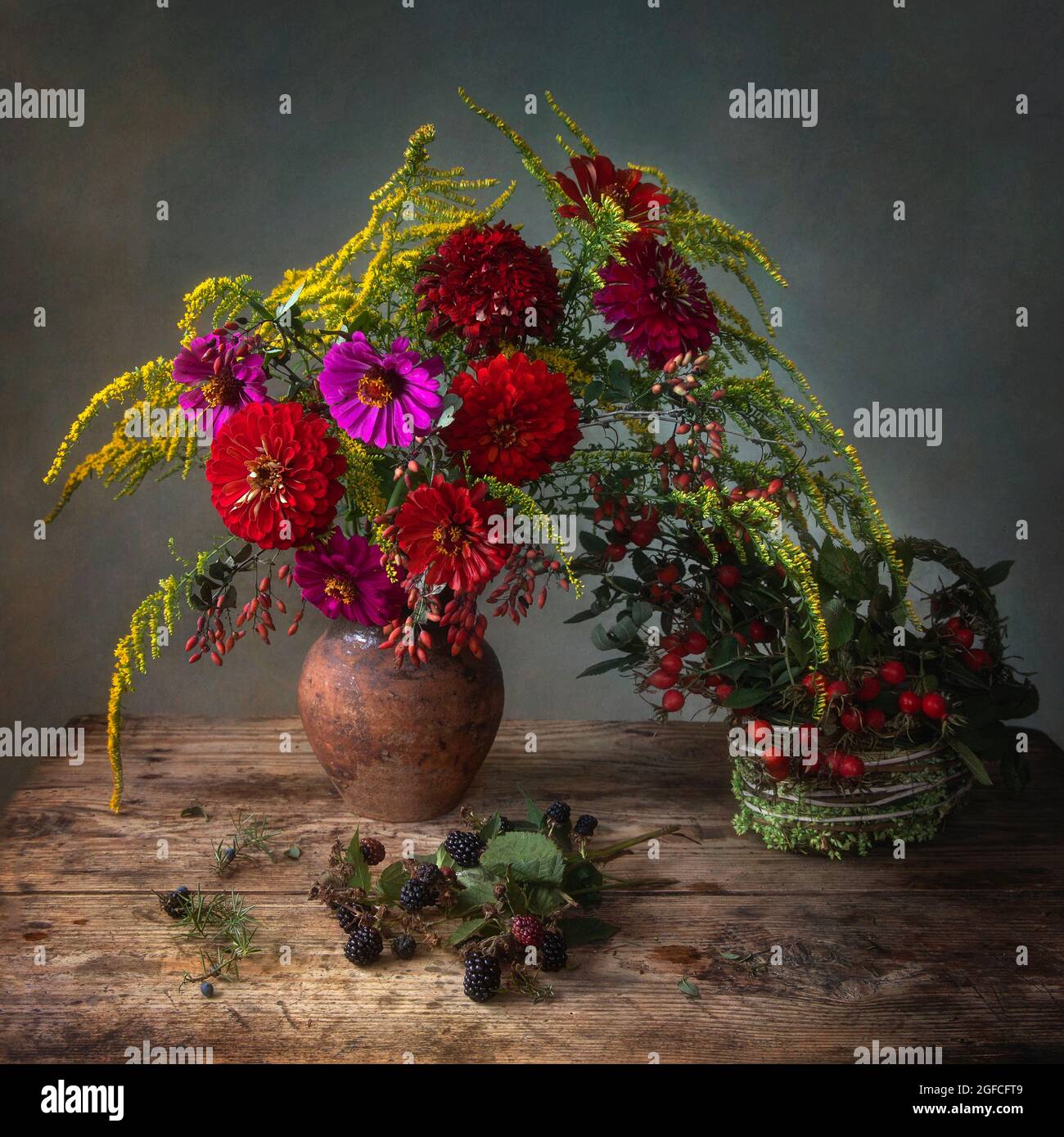 Still life with bouquet of garden flowers and forest fruits Stock Photo