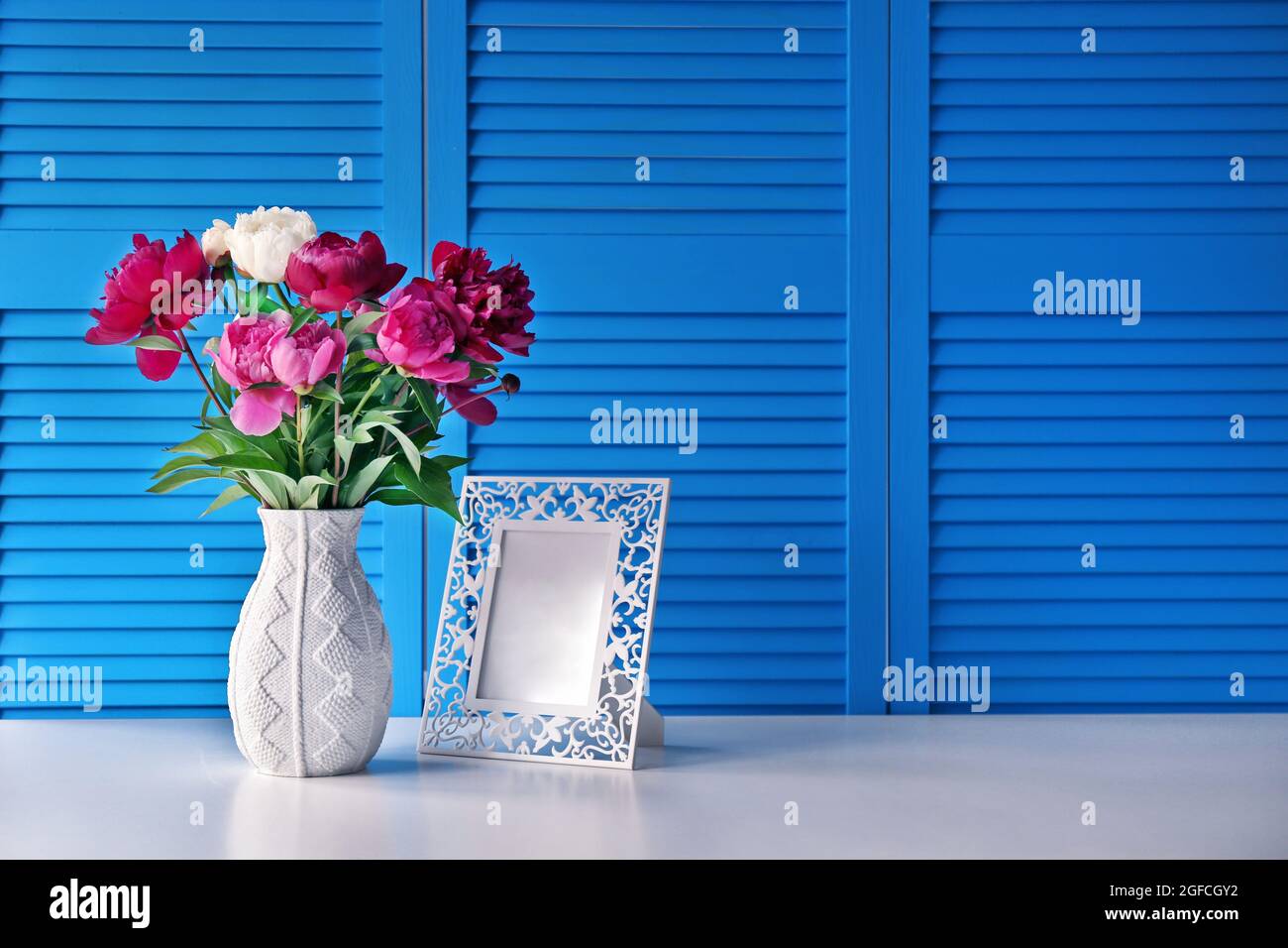 Beautiful peony bouquet on blue folding screen background Stock Photo