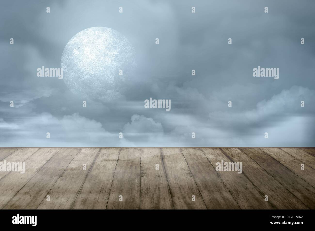 Wooden table with a full moon with dark cloudscapes on the night ...